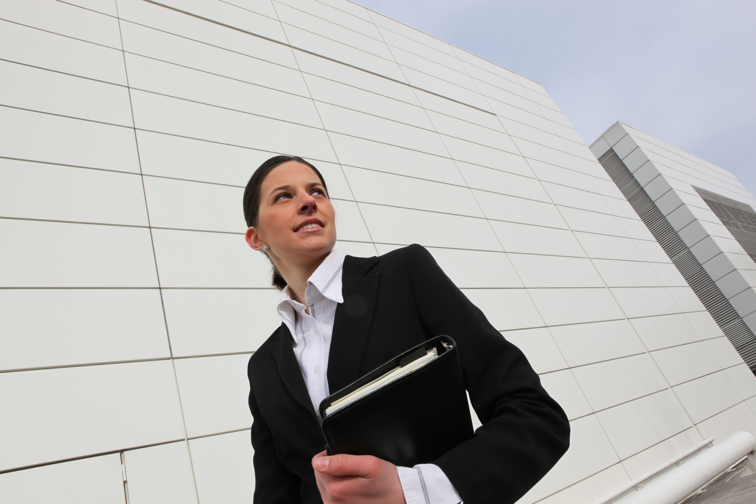 Organized female healthcare executive walking past hospital to an IRS 501(r) Compliance meeting